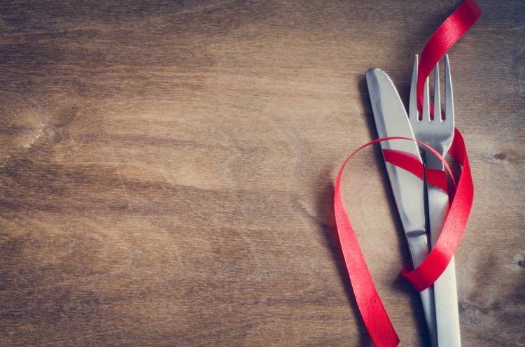 Cutlery Decorated with Red Ribbon on Wooden Background. Selective Focus. Space for Text. Toned image.