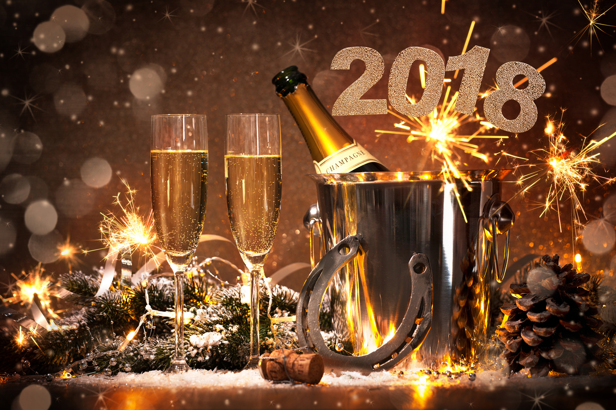 New Years Eve celebration background with pair of flutes and bottle of champagne in bucket and a horseshoe as lucky charm